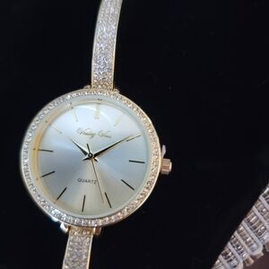 Womens Band finished gold watch with stones around the dial